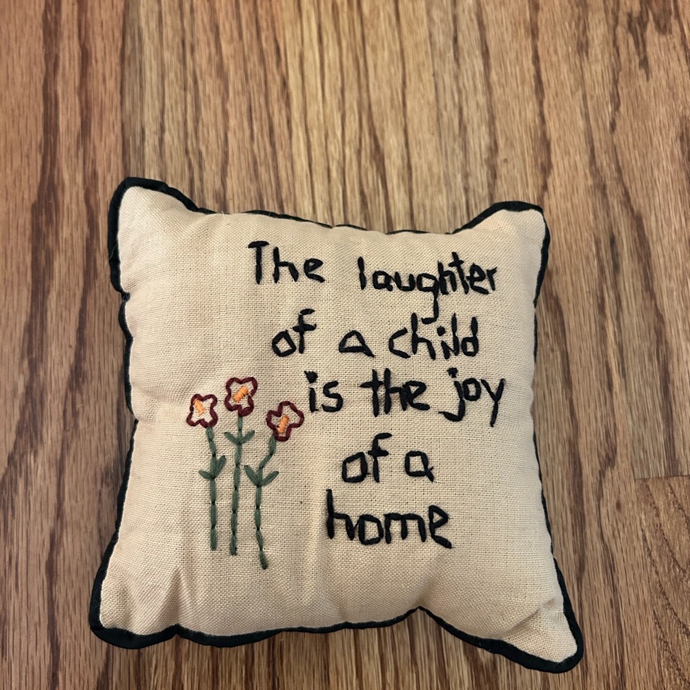 Small decorative throw pillow “The laughter of a child is the joy of a home”